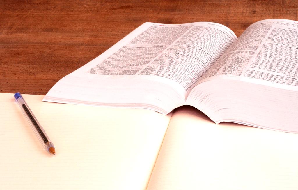 Student coding with beginner-level programming books on table